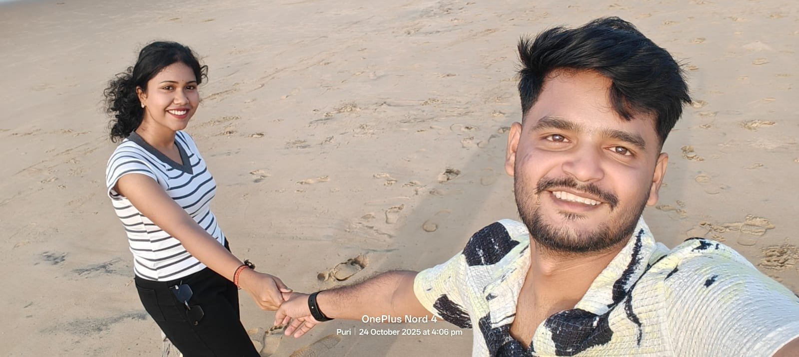 Our smiling beach selfie while holding hands